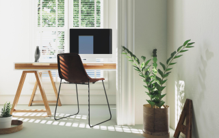 Simple, sunny office with white walls, view of trees, plants